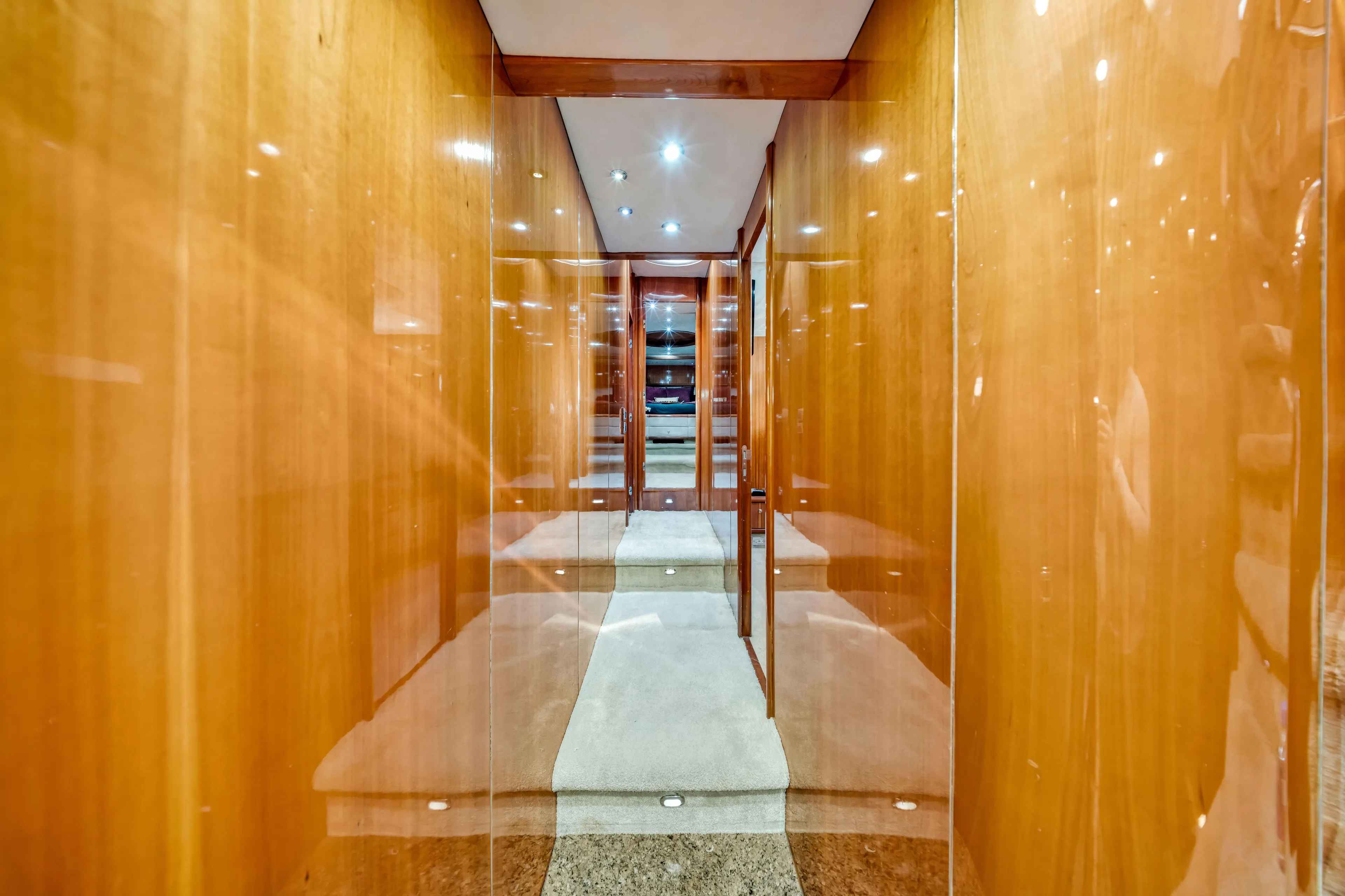 So What Who Cares Yacht Photos Pics Luxurious wooden hallway interior of 2003 Sunseeker 150 GT yacht, featuring elegant lighting.