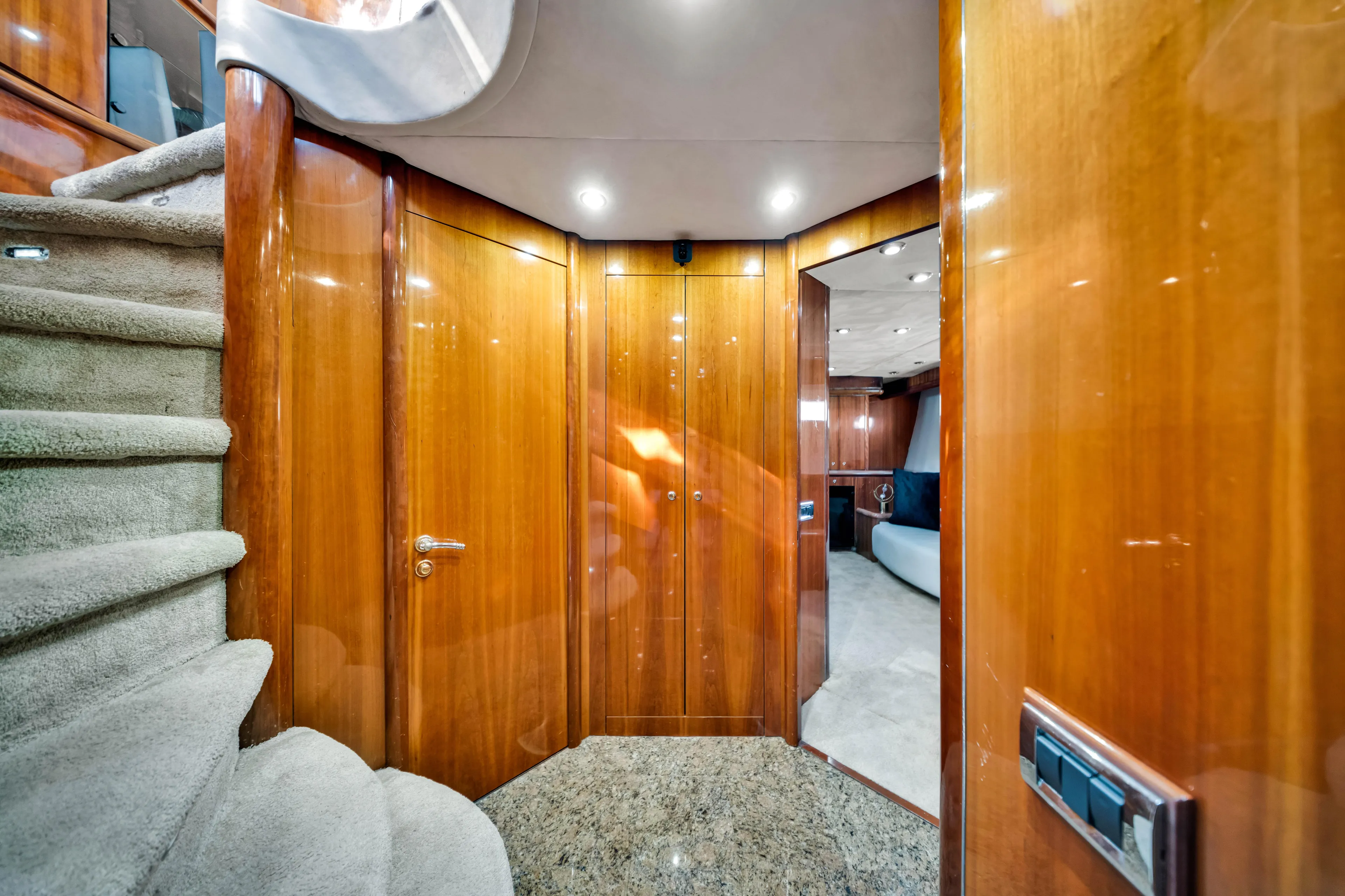 So What Who Cares Yacht Photos Pics Luxurious interior of 2003 Sunseeker 150 GT yacht with polished wood and carpeted stairs.