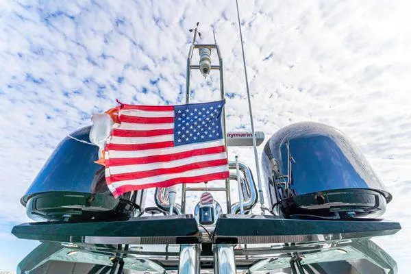  Yacht Photos Pics Monte Carlo Yachts MCY 70, 2018 model, with American flag against a cloudy sky.