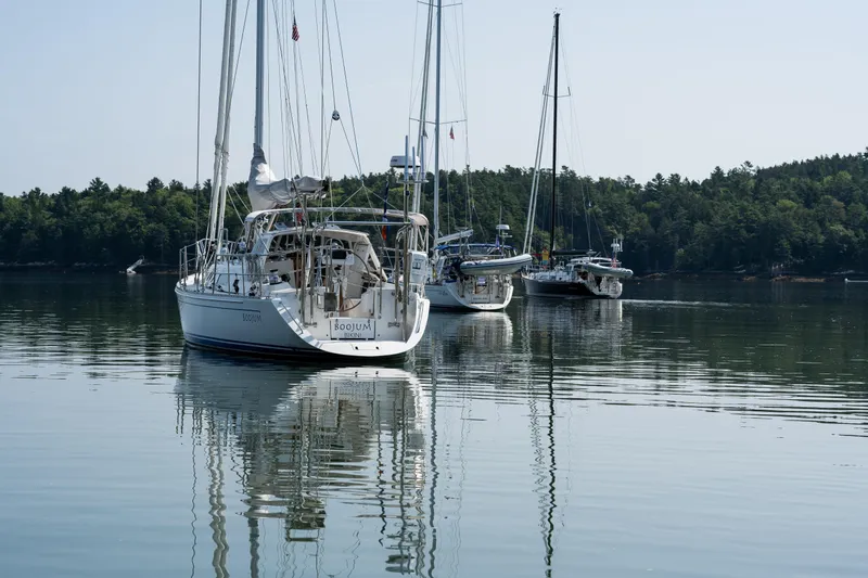 Boojum Yacht Photos Pics Sailboats, including a 2024 Outbound 46, anchored on a calm lake with forested shoreline.