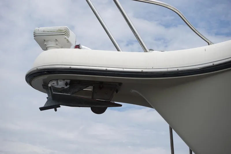  Yacht Photos Pics Bow of 1997 Pursuit 3400 Offshore boat with anchor and railing against cloudy sky.