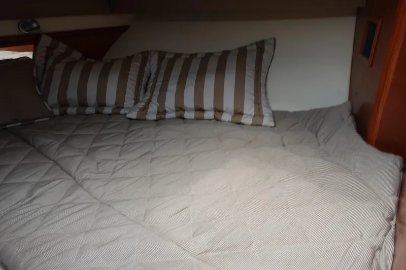  Yacht Photos Pics Cozy cabin bed with striped pillows in 1997 Pursuit 3400 Offshore boat.