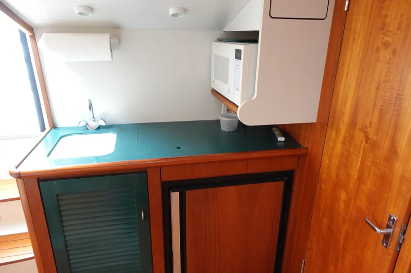  Yacht Photos Pics 1997 Pursuit 3400 Offshore boat interior with kitchenette, sink, and microwave.