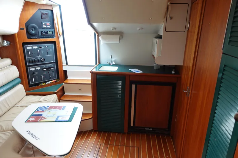  Yacht Photos Pics Interior of 1997 Pursuit 3400 Offshore boat with kitchenette and seating area.