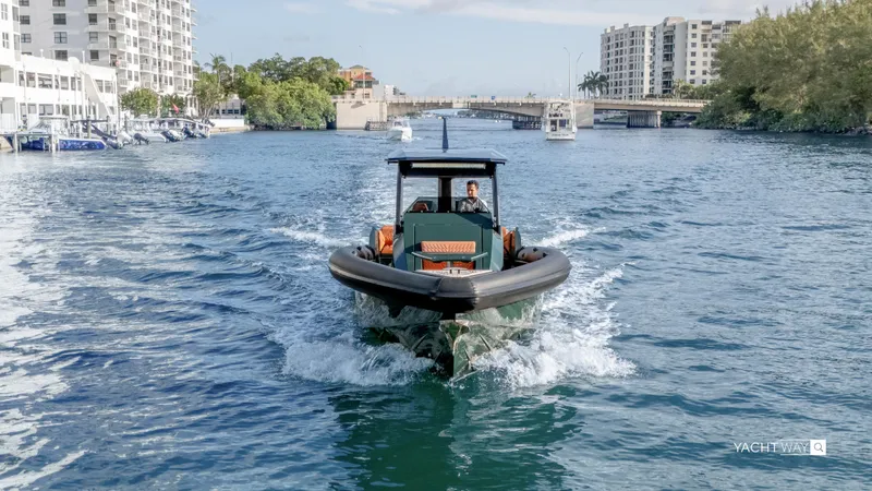 New 2025 Skipper 38 Twin 400 V10 Yacht Photos Pics 2025 Skipper-BSK 38 boat cruising in urban waterway with buildings and bridge in background.