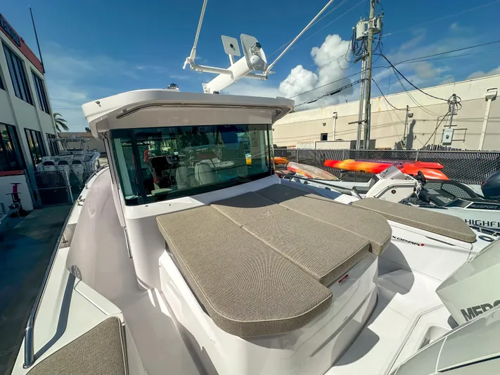  Yacht Photos Pics 2024 Axopar 37XC CROSS CABIN boat with sun deck, docked under clear sky.