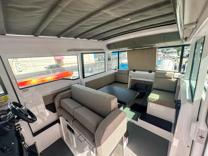  Yacht Photos Pics 2024 Axopar 37XC CROSS CABIN interior with seating and helm, showcasing modern design.