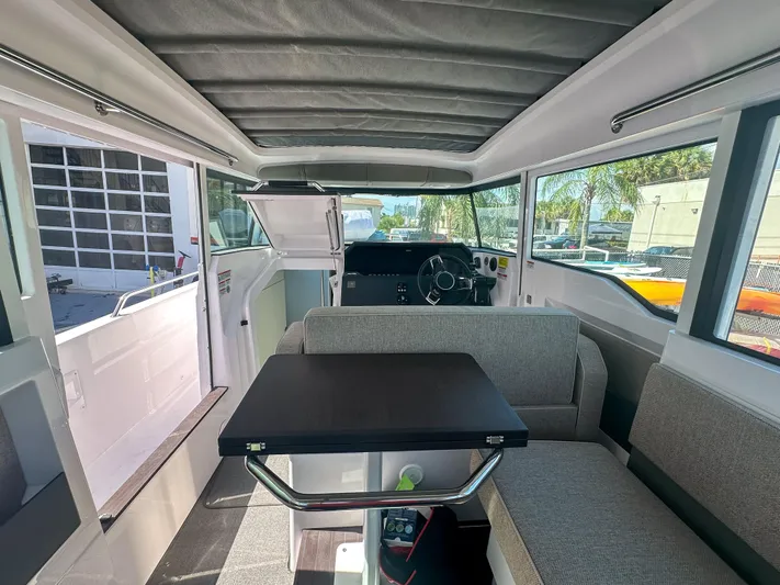  Yacht Photos Pics 2024 Axopar 37XC CROSS CABIN interior with seating and table, showcasing modern design.