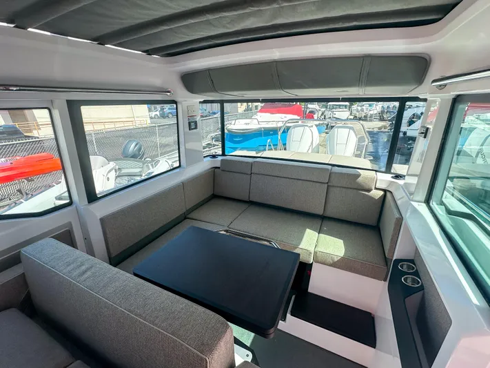  Yacht Photos Pics 2024 Axopar 37XC CROSS CABIN interior with modern seating and table, showcasing spacious design.