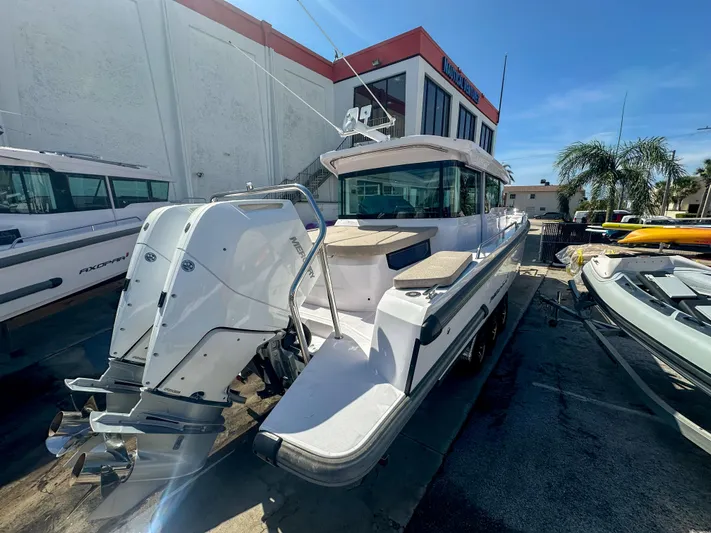  Yacht Photos Pics 2024 Axopar 37XC CROSS CABIN boat with dual outboard engines, docked outdoors.