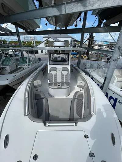  Yacht Photos Pics 2024 Sea Pro 320 DLX Center Console boat in storage, showcasing sleek design and seating.