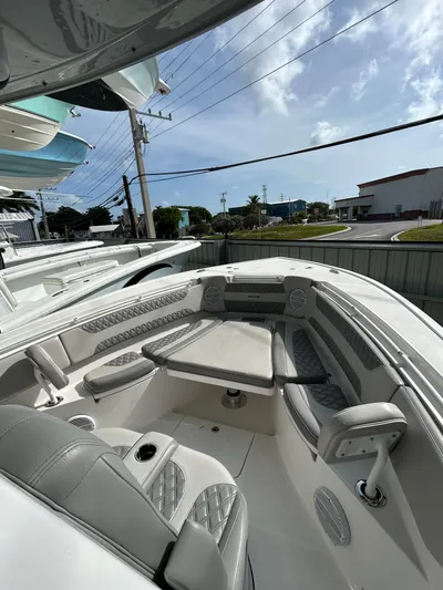  Yacht Photos Pics 2024 Sea Pro 320 DLX Center Console boat interior with cushioned seating and table.