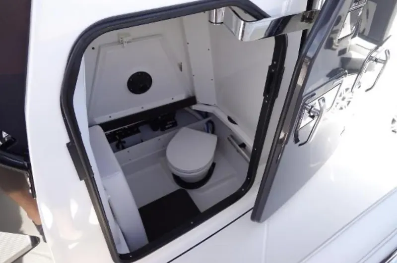  Yacht Photos Pics 2021 Blackfin 272 CC boat interior with compact marine toilet and storage space.