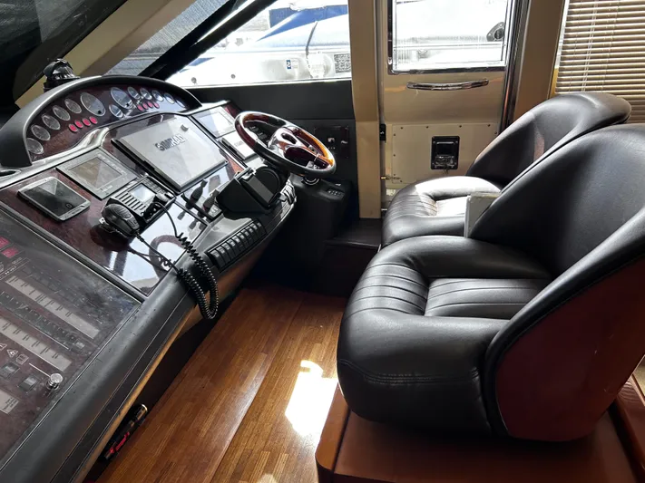 Just Chillin Yacht Photos Pics 2006 Viking Princess 61 Flybridge helm with leather seats and advanced navigation controls.