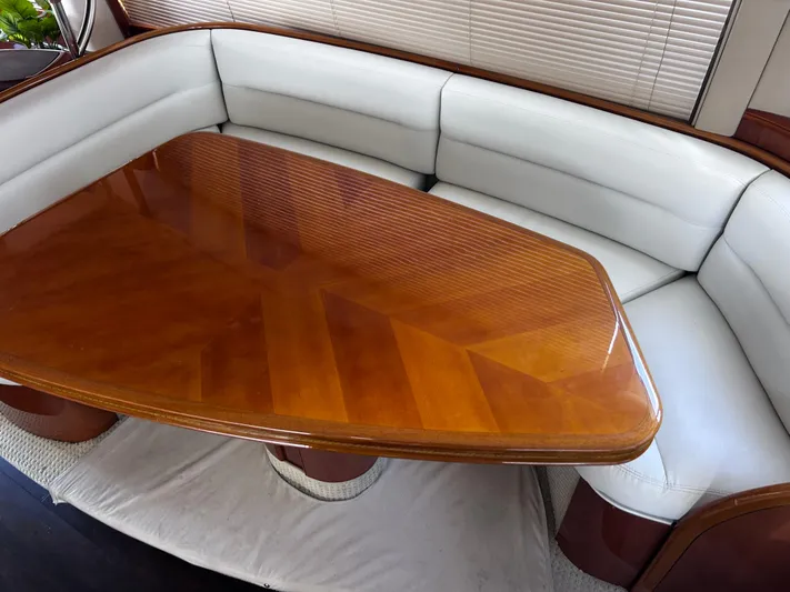 Just Chillin Yacht Photos Pics Luxurious interior of 2006 Viking Princess 61 Flybridge with elegant wood table and plush seating.