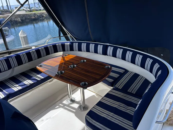 Just Chillin Yacht Photos Pics Luxurious 2006 Viking Princess 61 Flybridge with elegant seating and polished wooden table.
