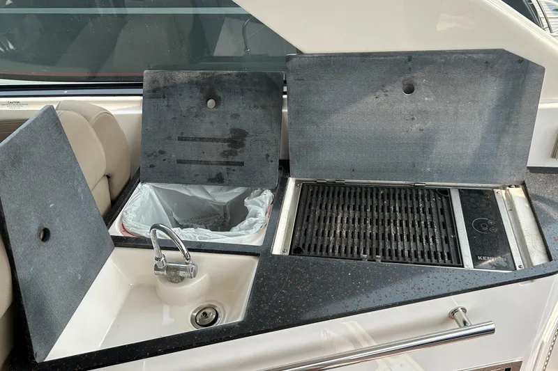 Sound Decision Yacht Photos Pics 2013 Regal 35 Sport Coupe boat kitchen with sink, trash bin, and grill.