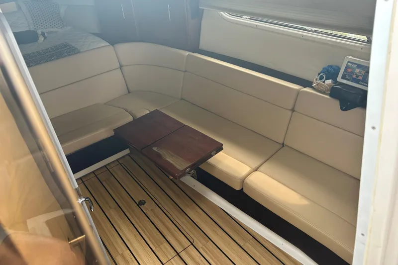 Sound Decision Yacht Photos Pics Interior of 2013 Regal 35 Sport Coupe with beige seating and wooden table.