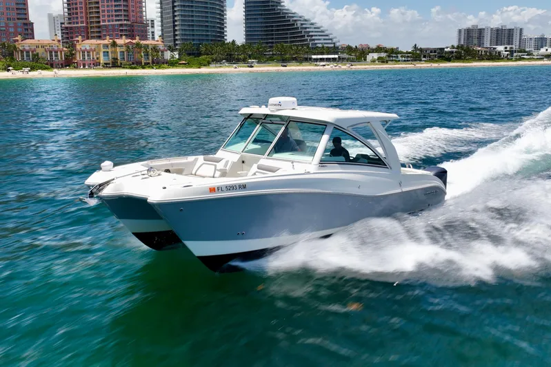  Yacht Photos Pics 2018 World Cat 320 DC cruising on blue water near a city skyline.