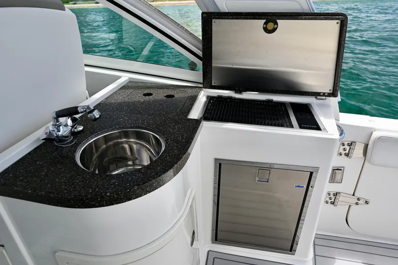  Yacht Photos Pics 2018 World Cat 320 DC boat kitchenette with sink, grill, and mini fridge.