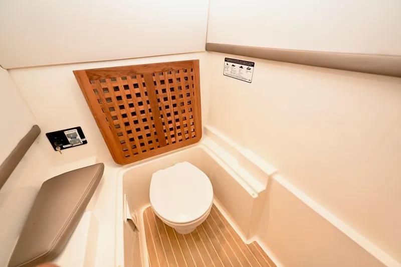  Yacht Photos Pics 2018 World Cat 320 DC boat bathroom with wooden accents and modern fixtures.