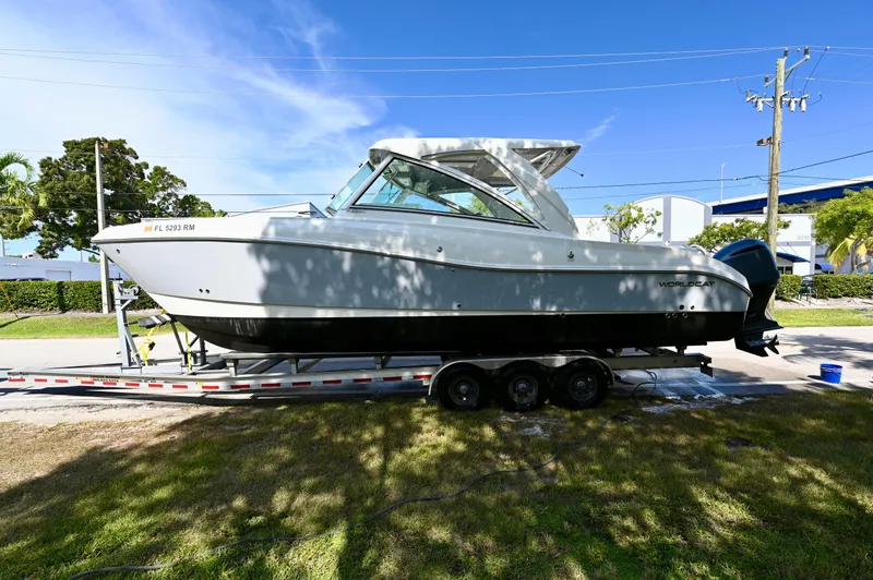  Yacht Photos Pics 2018 World Cat 320 DC boat on trailer, parked outdoors under clear blue sky.