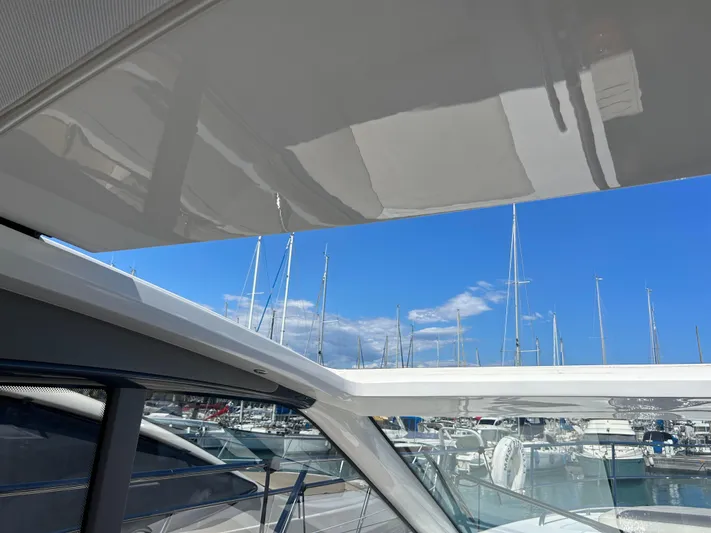  Yacht Photos Pics 2020 Princess V50 yacht with marina view, showcasing sleek design and clear blue sky.