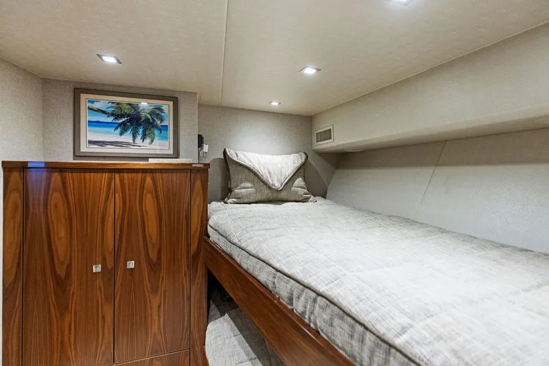  Yacht Photos Pics Luxurious cabin interior of 2018 Viking 80 Convertible yacht with cozy bed and wooden cabinetry.