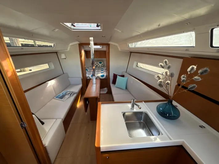  Yacht Photos Pics 2024 Jeanneau Sun Odyssey 350 interior with modern kitchen, cozy seating, and elegant decor.