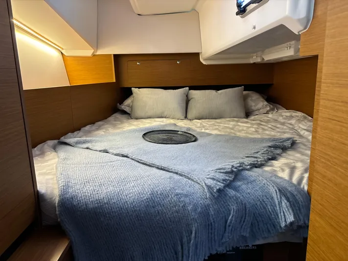  Yacht Photos Pics Cozy cabin interior of 2024 Jeanneau Sun Odyssey 350 with plush bedding and soft lighting.