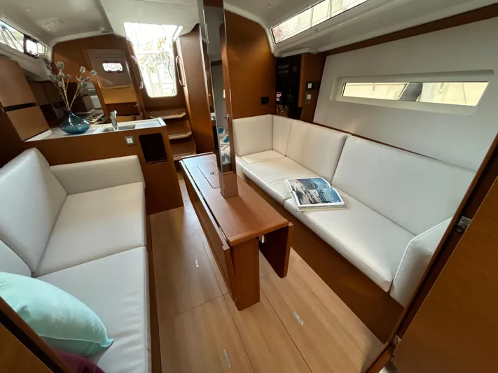  Yacht Photos Pics 2024 Jeanneau Sun Odyssey 350 interior with modern seating and wooden finishes.