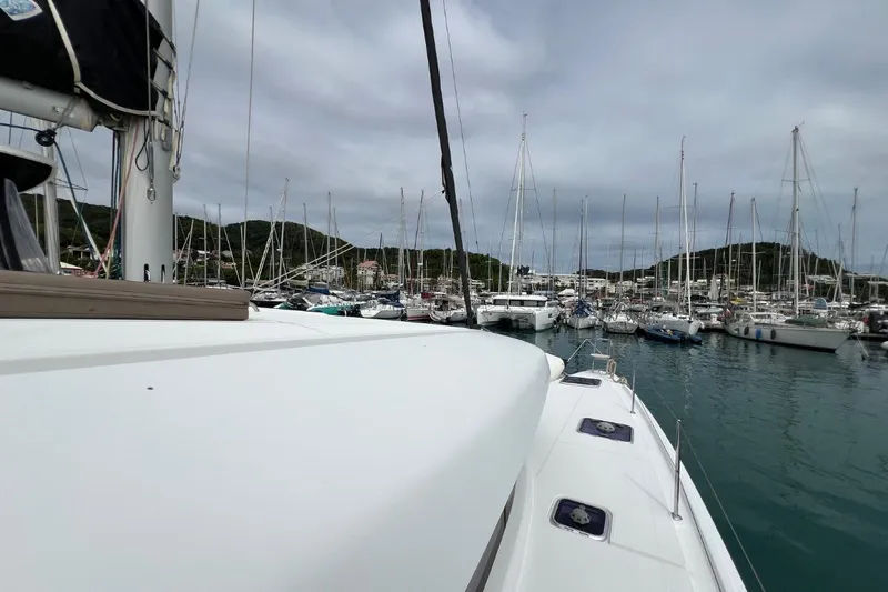 Mocean Yacht Photos Pics Lagoon 42 catamaran in a marina, surrounded by sailboats, under cloudy skies.