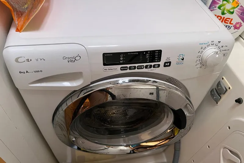 Mocean Yacht Photos Pics Front-loading washing machine with digital controls and detergent nearby.