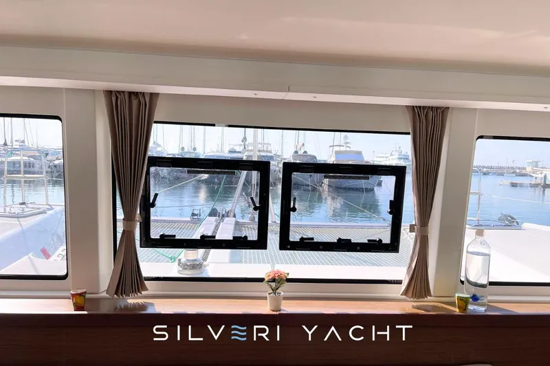  Yacht Photos Pics Interior view from a 2019 Lagoon 42 yacht, overlooking a marina through large windows.
