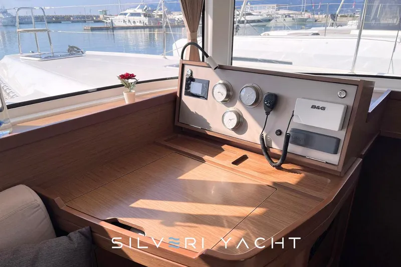  Yacht Photos Pics Interior view of 2019 Lagoon 42 yacht with navigation instruments and marina backdrop.