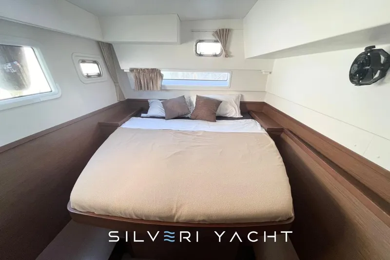  Yacht Photos Pics Cozy cabin interior of 2019 Lagoon 42 yacht with comfortable bed and pillows.