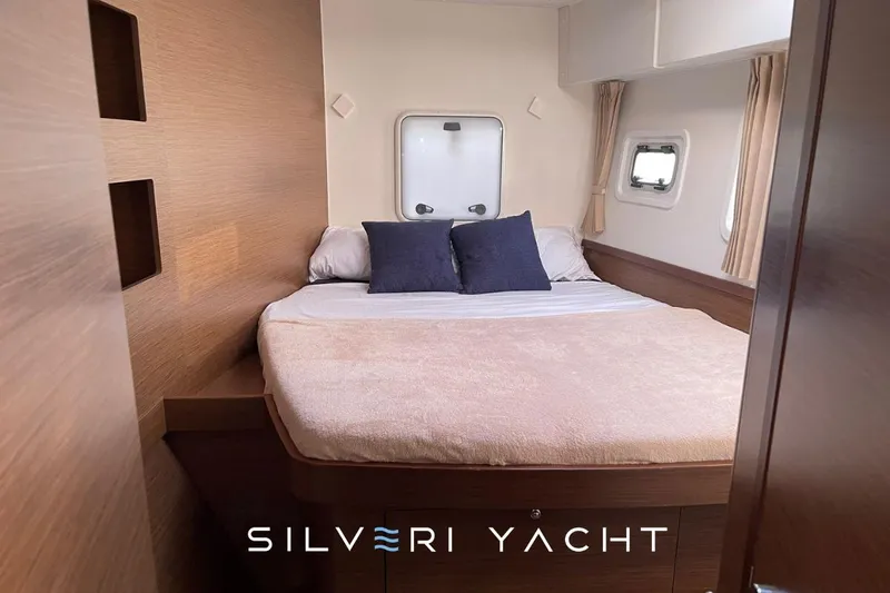  Yacht Photos Pics Luxurious cabin interior of 2019 Lagoon 42 yacht with cozy bed and elegant decor.