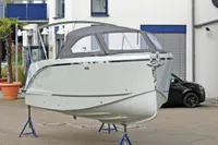 2024 Maxima 740 boat displayed on stands, with a sleek design and covered cockpit.