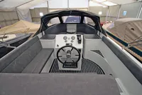 2024 Maxima 740 boat interior with steering wheel and seating in a covered storage area.