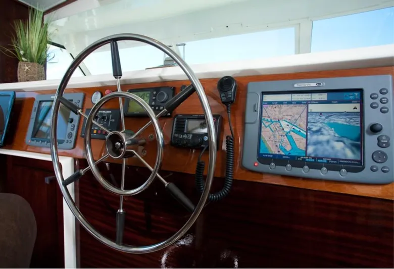 Savoy Yacht Photos Pics 1970 Chris-Craft Commander helm with modern navigation equipment and classic wooden dashboard.