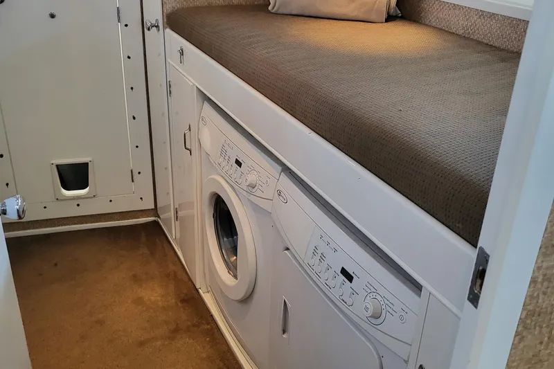 Savoy Yacht Photos Pics 1970 Chris-Craft Commander interior with built-in washer and dryer under a cushioned bench.