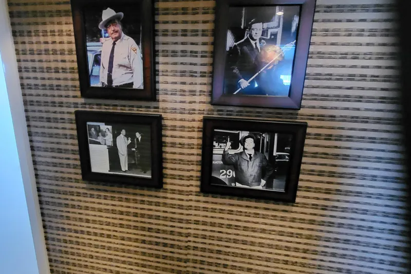 Savoy Yacht Photos Pics Four framed black-and-white photos on a patterned wall, featuring various individuals.