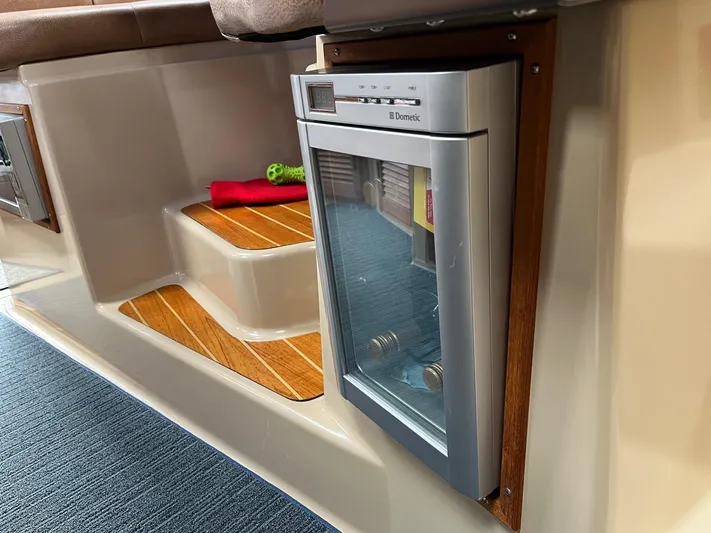  Yacht Photos Pics Compact fridge in 2012 Ranger Tugs R-29 boat interior with wooden steps and carpet.