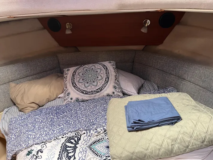  Yacht Photos Pics Cozy cabin interior of 2012 Ranger Tugs R-29 with patterned bedding and folded linens.