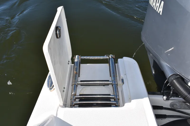  Yacht Photos Pics 2022 Robalo R272 Center Console boat with a folded swim ladder and Yamaha engine.