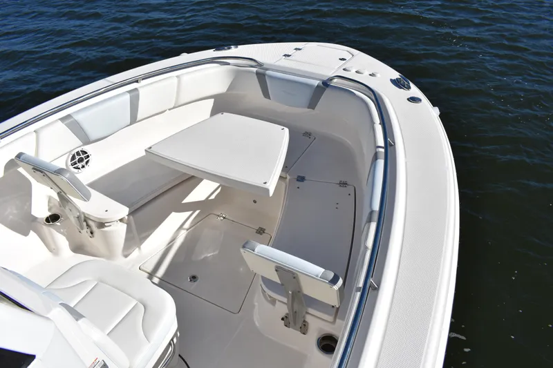  Yacht Photos Pics 2022 Robalo R272 Center Console boat interior with seating and table on water.