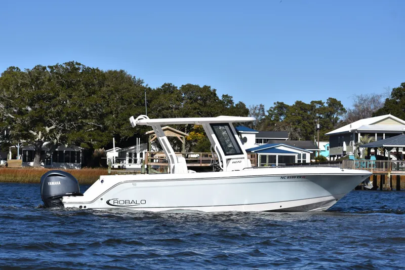  Yacht Photos Pics 2022 Robalo R272 Center Console boat on water near shoreline homes.