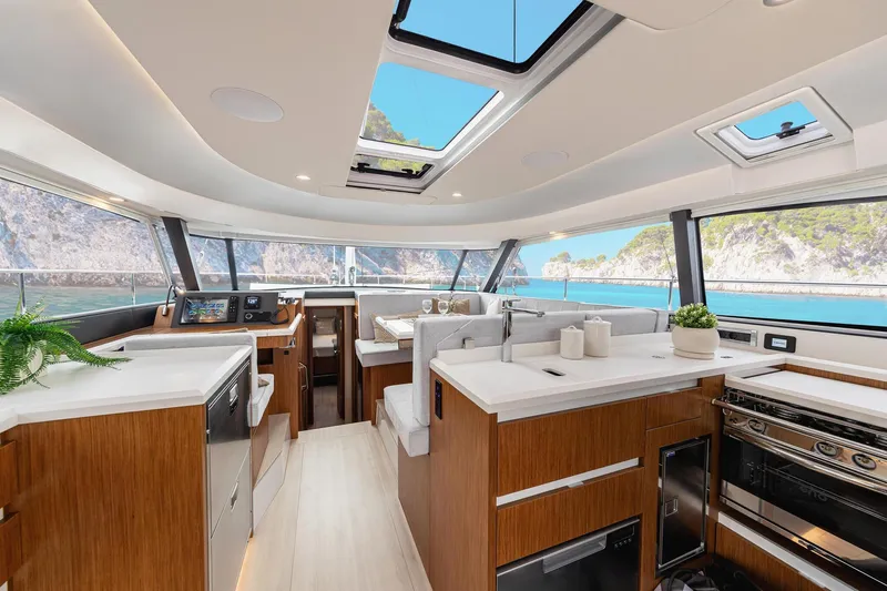  Yacht Photos Pics Luxurious interior of 2026 Moody 48DS yacht with modern kitchen and scenic ocean view.