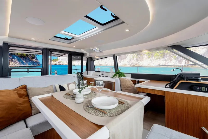  Yacht Photos Pics Luxurious interior of 2026 Moody 48DS yacht with ocean view and elegant dining setup.