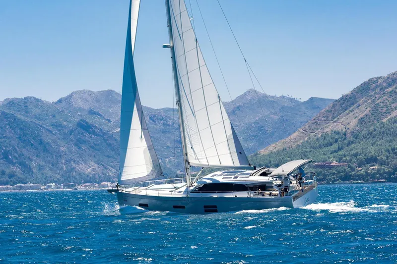  Yacht Photos Pics Sailing yacht Moody 48DS 2026 gliding on blue sea with mountainous backdrop.